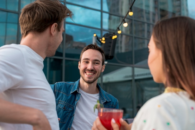 Uomo sorridente accanto agli amici ad una festa