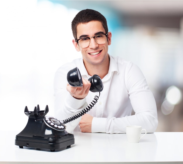 Uomo sorridente che comunica su un telefono nero