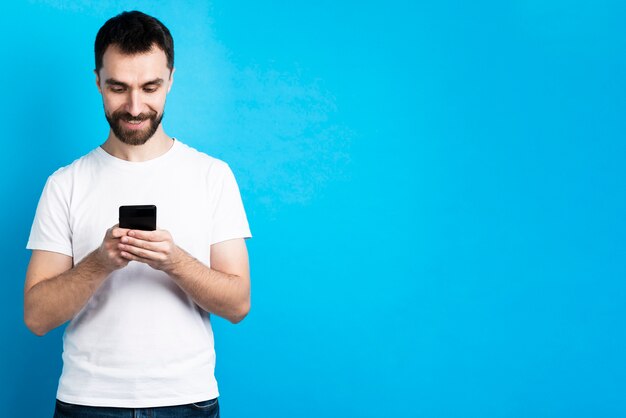 Uomo sorridente che esamina smartphone