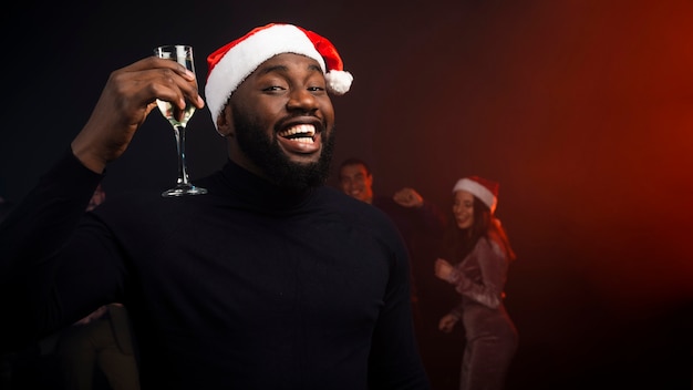 Uomo sorridente che incoraggia con il vetro del champagne per i nuovi anni