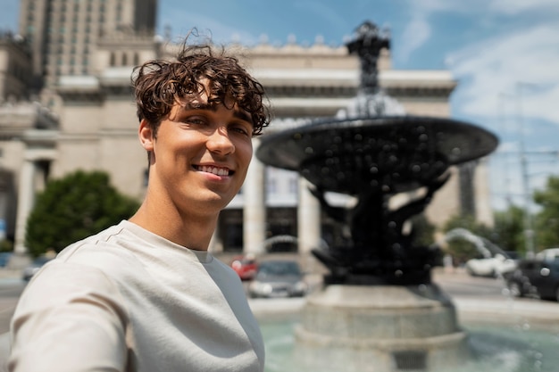 Uomo sorridente che prende selfie medio