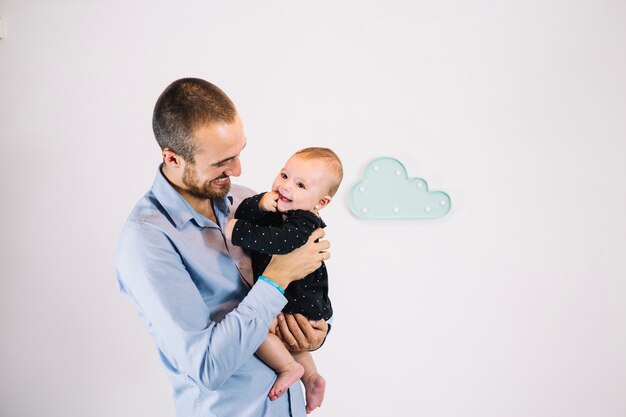 Uomo sorridente che tiene bambino allegro