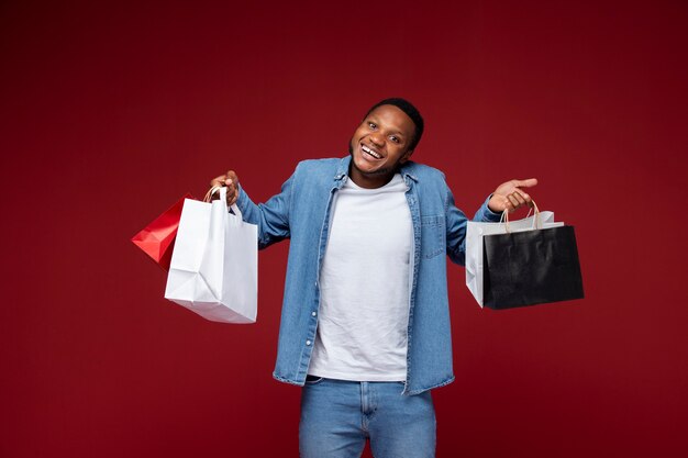 Uomo sorridente che tiene le borse della spesa colpo medio