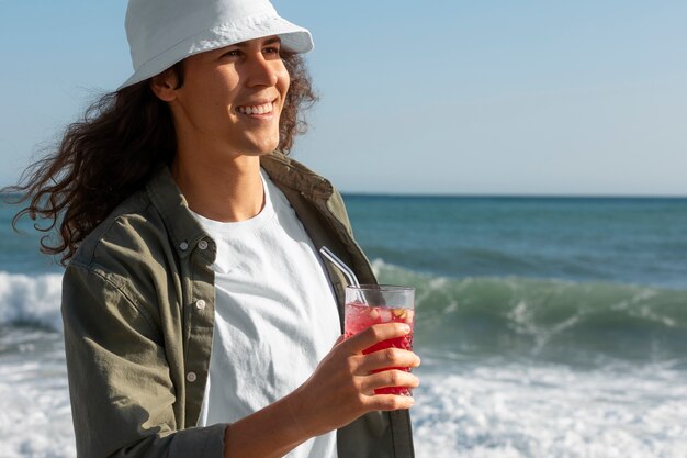 Uomo sorridente con colpo medio che tiene drink