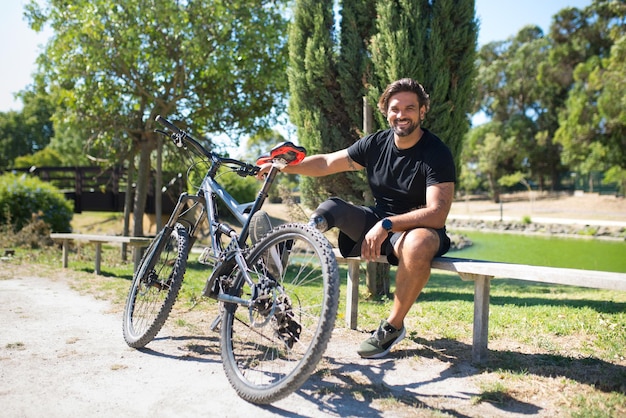 Uomo sorridente con disabilità con bicicletta