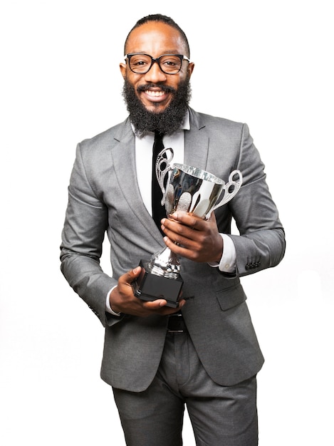 Uomo sorridente con il vestito e il trofeo