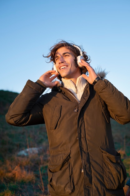 Uomo sorridente con tiro medio con le cuffie