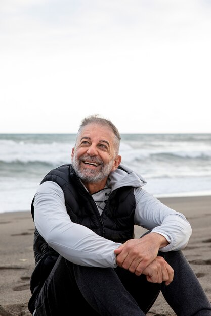 Uomo sorridente del colpo medio alla spiaggia