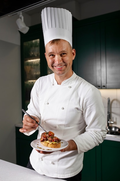 Uomo sorridente del colpo medio che tiene piatto di cibo