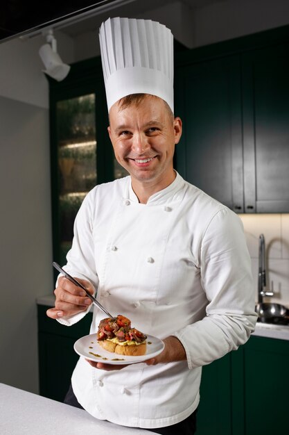 Uomo sorridente del colpo medio che tiene piatto di cibo