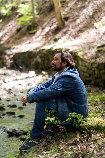 Uomo sorridente del colpo pieno che si gode la natura