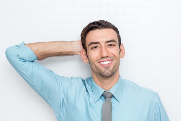 Uomo sorridente di affari con la mano dietro la testa