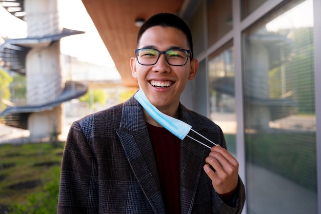 Uomo sorridente di colpo medio che tiene maschere