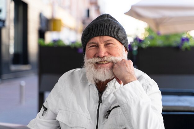 Uomo sorridente di tiro medio seduto alla terrazza