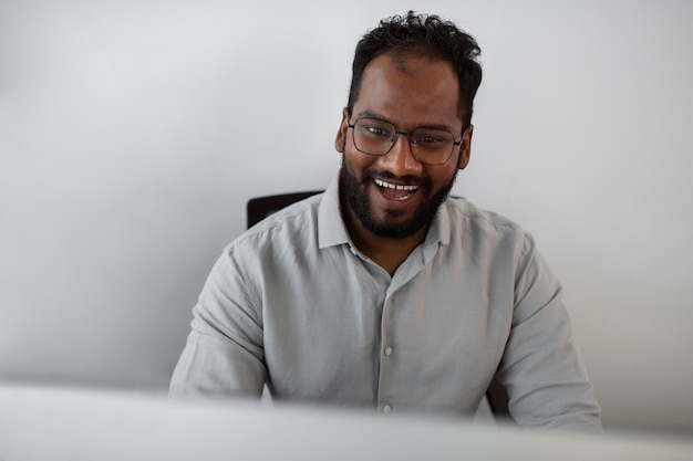 Uomo sorridente di vista frontale al lavoro