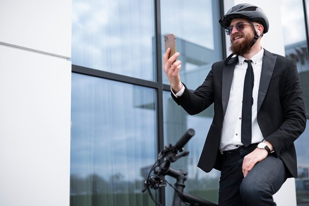 Uomo sorridente di vista laterale che tiene smartphone