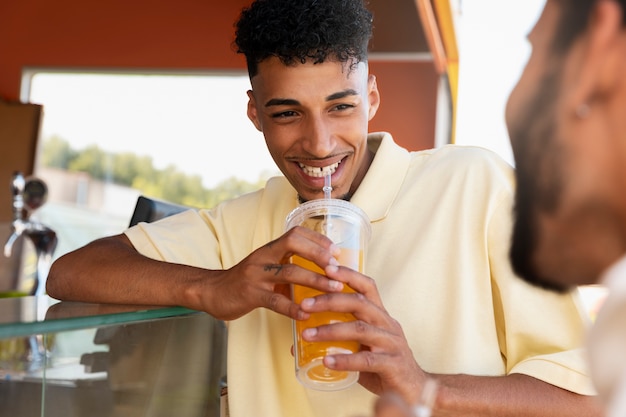 Uomo sorridente di vista laterale con la bevanda