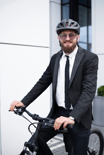 Uomo sorridente di vista laterale in tuta in bicicletta al lavoro