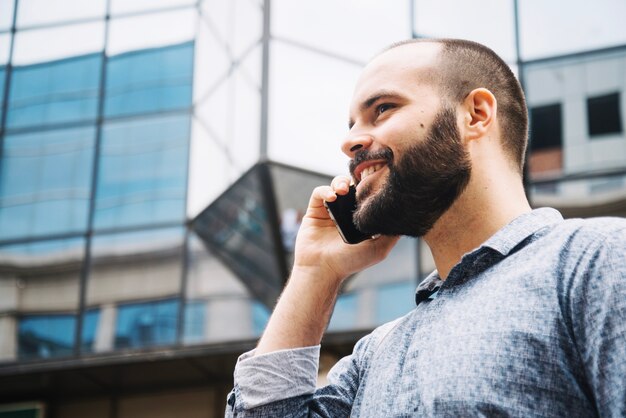 Uomo sorridente godendo telefono parlando