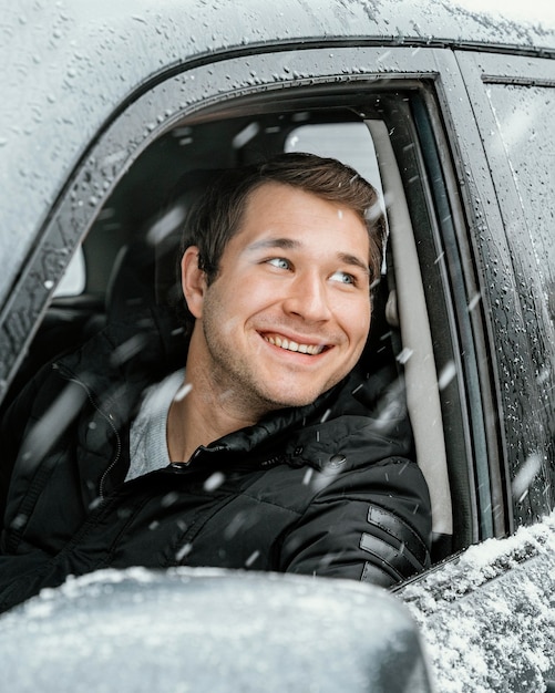 Uomo sorridente in macchina durante un viaggio su strada