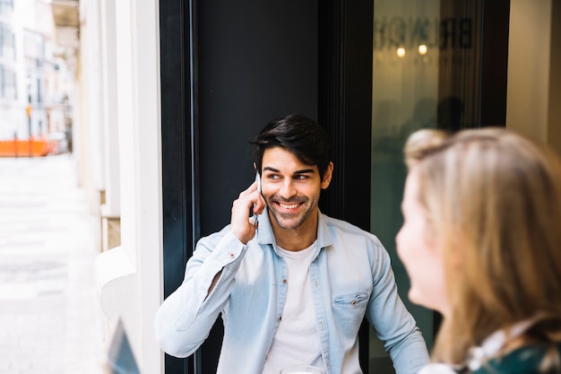 Uomo sorridente parlando su smartphone