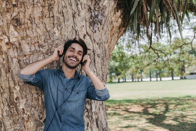 Uomo spensierato godendo la musica nel parco