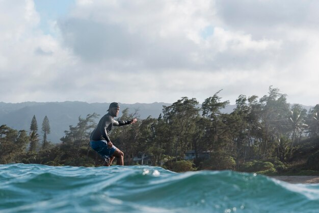 Uomo sportivo che fa surf alle hawaii