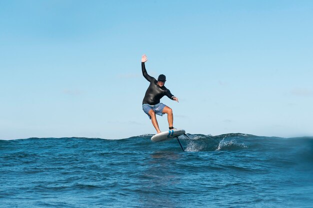 Uomo sportivo che fa surf alle hawaii