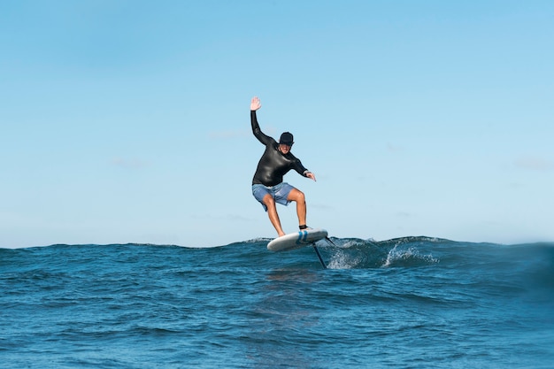 Uomo sportivo che fa surf alle hawaii