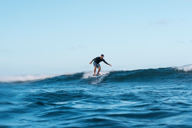 Uomo sportivo che fa surf alle hawaii