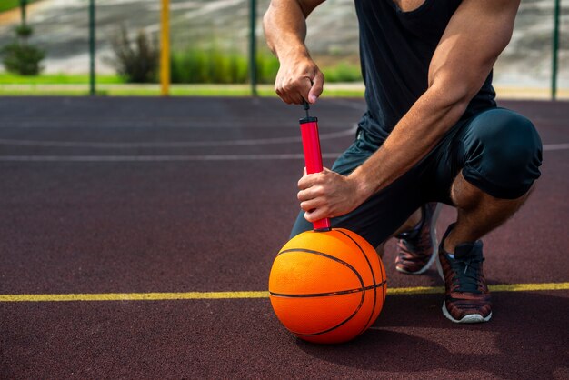 Uomo sportivo che gonfia una palla