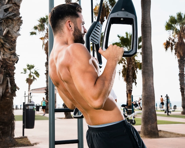 Uomo sportivo del primo piano che fa i pull-up