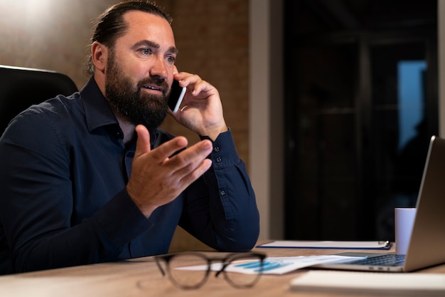 Uomo stanco che lavora fino a tardi in ufficio