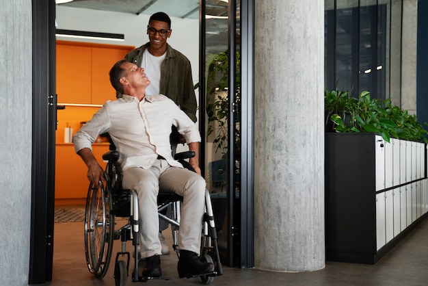 Uomo su una sedia a rotelle che ha un lavoro d'ufficio inclusivo