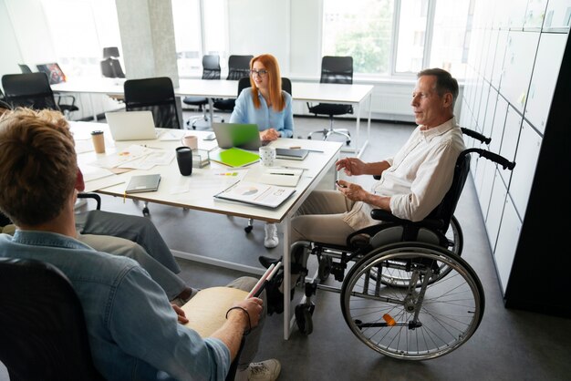 Uomo su una sedia a rotelle che ha un lavoro d'ufficio