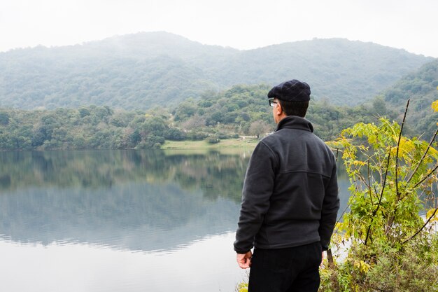 Uomo sul lago godendo il paesaggio