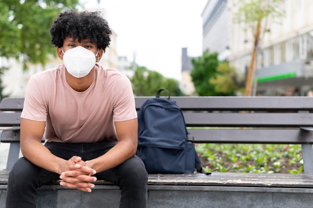 Uomo sulla panchina che indossa la maschera