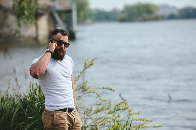 uomo tranquillo parlando al telefono con sfondo il lago