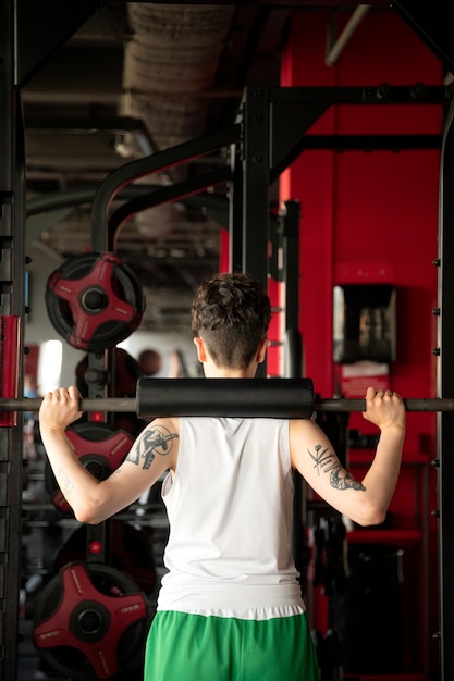 Uomo trans che si allena e si esercita in palestra