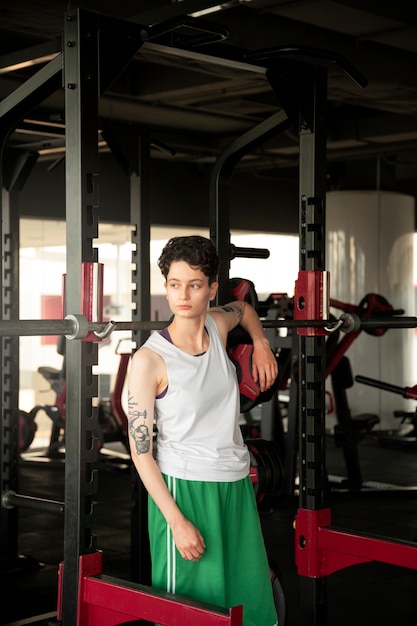 Uomo trans che si allena e si esercita in palestra