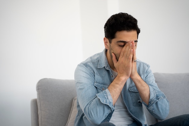 Uomo triste di tiro medio a casa