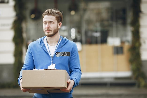 Uomo vicino al camion. Ragazzo in uniforme da consegna.