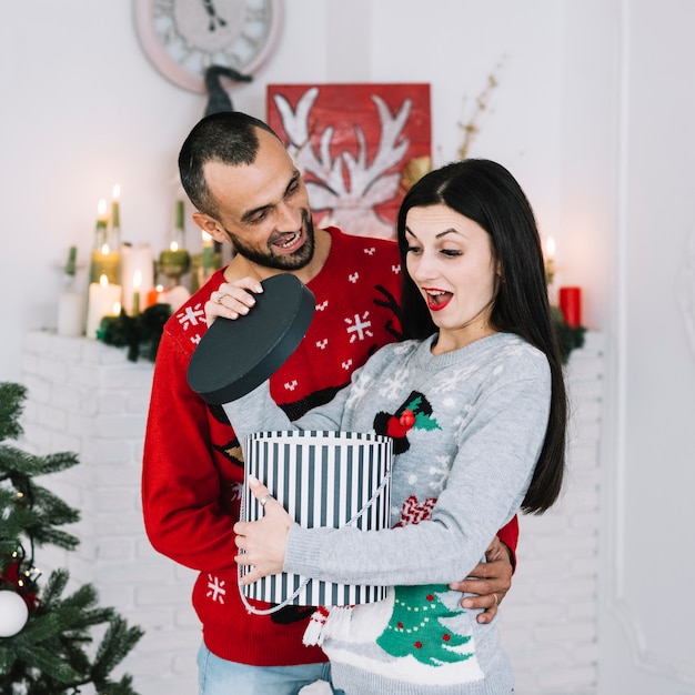 Uomo vicino donna sorpresa con regalo