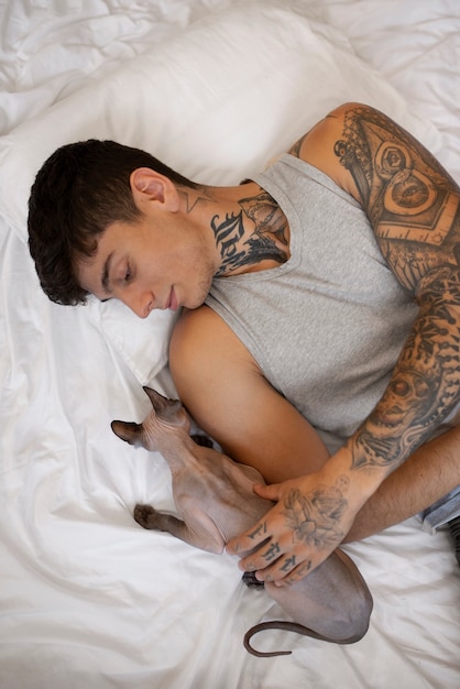 Uomo vista dall'alto sdraiato a letto con il gatto