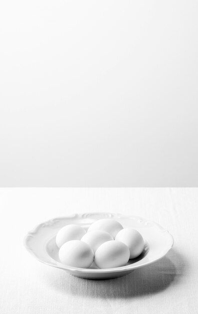 Uova bianche ad alto angolo sul piatto con copia-spazio