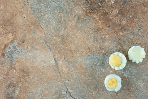 Uova bollite a fette sul tavolo di marmo.