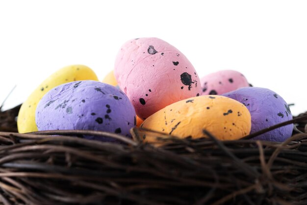 Uova di Pasqua colorate all'interno di un nido isolato su sfondo bianco