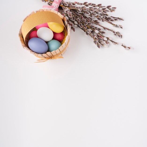 Uova di Pasqua in cestino di legno con rami di salice