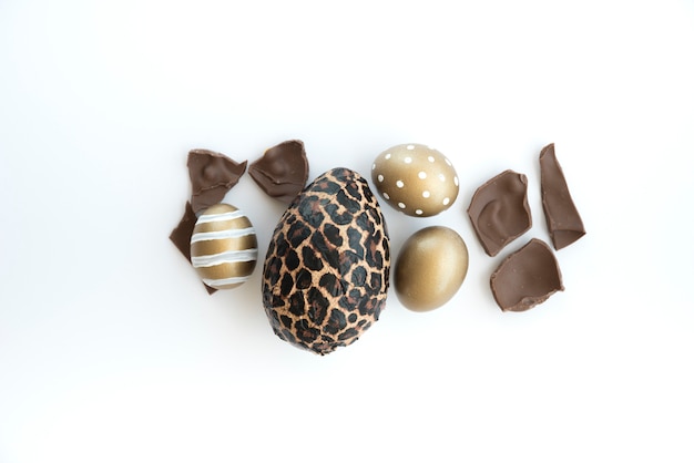 Uova di Pasqua variopinte con l&#39;uovo di cioccolato sulla tavola