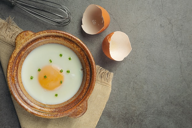 Uova in un cesto di paglia e un libro di cucina Concetto di nutrizione alimentare.